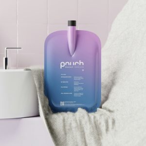 a purple bottle sitting on top of a bed next to a sink